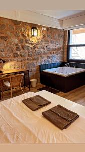 贝尔加马阿塔洛斯套房酒店的带浴缸的浴室以及带毛巾的床。