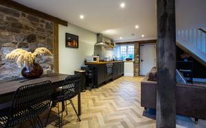 切普斯托Gardener's Cottage的厨房配有桌椅和石墙