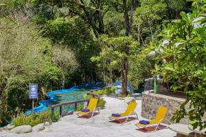 利比里亚Buena Vista del Rincón Eco Adventure Park Hotel & Spa的一组椅子坐在泳池旁的庭院里