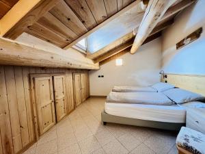 利维尼奥Chalet Nicolin的一间带一张床的卧室,位于带木制天花板的房间内