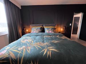 洛默尔Red cross street的一间卧室配有一张大床,床罩蓝色,棕榈树环绕