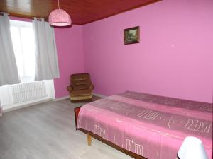 Gite Bellevue的卧室设有紫色墙壁、一张床和一把椅子