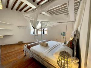 帕杰Duara Beach House的一间卧室配有一张带吊灯的天蓬床