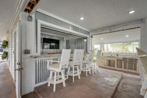 加尔维斯敦Bayfront Jamaica Beach House Canal Access and Decks的带白色椅子的酒吧和厨房的房间