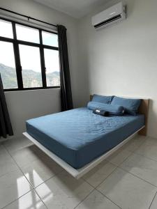 峇六拜Sun Executive Suite Entire Unit @Bayan Lepas #5pax #Queensbay #SPICE #100Mbps的一间卧室配有一张带蓝色床单的床和一扇窗户。