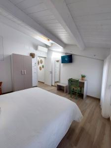 圣贝内代托-德尔特龙托Affittacamere Casa Lilibet的卧室配有一张白色的大床和一张桌子