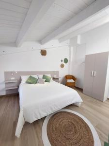 圣贝内代托-德尔特龙托Affittacamere Casa Lilibet的白色卧室配有大床和地毯