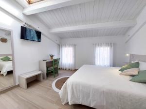 圣贝内代托-德尔特龙托Affittacamere Casa Lilibet的白色卧室配有床和书桌