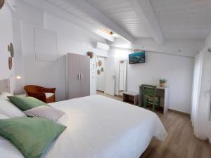 圣贝内代托-德尔特龙托Affittacamere Casa Lilibet的白色卧室配有一张大床和一张桌子