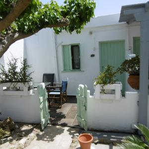 斯基罗斯岛Skyros Panorama Studios的白色墙壁和盆栽桌子的房子