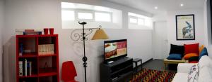 纳扎雷Lab Hostel Nazare的一间带电视和红色书架的客厅