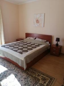 KoshkolʼRaduga West Pineforest - коттедж в аренду на Иссык-Куле的一间卧室配有一张大床和地毯。