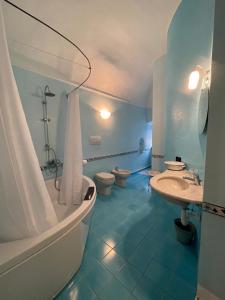 托伊拉诺Bed & Breakfast Scià Dina的浴室配有2个卫生间、浴缸和水槽