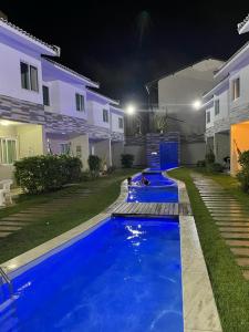 嘎林海斯港Casa de Luxo, 1 quadra do Mar em Porto de Galinhas的夜间在房子前面的游泳池