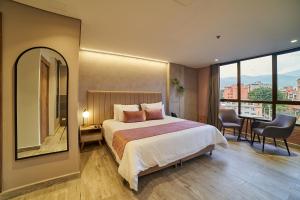 麦德林Eutopiq Hotel的一间卧室设有一张大床和一个大镜子