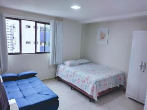 累西腓Home Boa Viagem的一间卧室配有一张床和一张蓝色的沙发