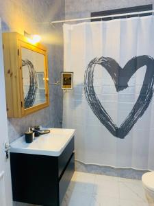 马达巴Laura's Cozy HOME的浴室设有水槽和抽心的淋浴帘。