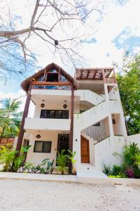 巴卡拉尔Casa de Piedra - Departamentos en Bacalar的海滩上树木繁茂的房子
