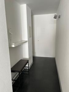 锡永Appartement Tourbillon centre-ville的一个空房间,有长凳和白色的墙壁