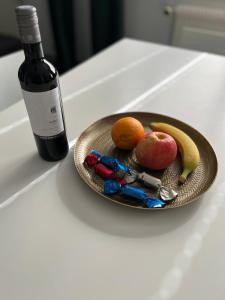 锡永Appartement Tourbillon centre-ville的桌上的水果盘和一瓶葡萄酒
