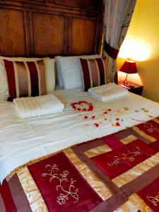 诺里奇草原农场小屋酒店的一张带红白毯子和枕头的床