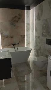 罗兹Manu Park Apartament z Garażem Centrum的带浴缸、卫生间和盥洗盆的浴室