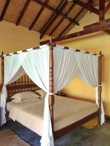 毛梅雷Waiara Village Guesthouse的卧室配有带白色窗帘的天蓬床