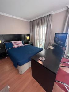 圣保罗HOTEL PERDIZES - FLAT Executivo - 1403的一间卧室配有一张床和一张带笔记本电脑的书桌