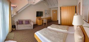 梅尔斯堡舍恩布吕克体育酒店的酒店客房,配有床和沙发