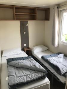 翁赞Camping Siblu domaine de Dugny的小型客房 - 带2张床和窗户