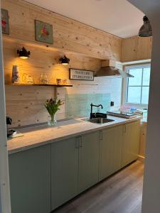 盖伦基兴RL Guesthouses的一间带木墙、水槽和柜台的厨房