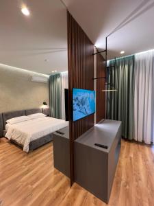 培拉特Bujtina Apsus的一间卧室配有一张床和一台平面电视
