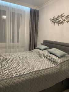 拉塔Jurata Apartament Glamour的一间卧室配有一张带两个枕头的床