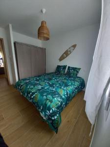 卡尔康Maison au calme avec piscine的一间卧室配有一张带绿色棉被的床
