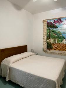 弗洛里Seaview apartments的卧室配有一张床,墙上挂有绘画作品