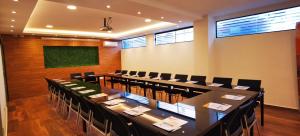 圣克鲁斯Premium Suites Deluxe Aparthotel Equipetrol的一间会议室,配有长桌子和椅子