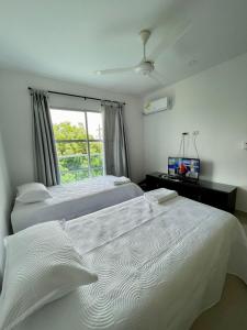 蒙特里亚CIC APARTAMENTOS cerca UNICOR IMAT的一间卧室设有两张白色的床和窗户
