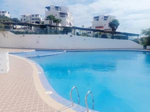 卡博尼格洛Charmant Studio piscine mdiq CaboNégro Martil的一个大型蓝色游泳池,其建筑背景为: