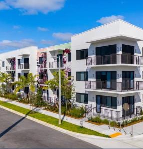 西棕榈滩Luxe & cozy 3Beds,2rooms,EV Gym Near Beaches&Downtown WPB的白色的公寓楼,位于街道上,设有阳台