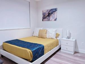 西棕榈滩Luxe & cozy 3Beds,2rooms,EV Gym Near Beaches&Downtown WPB的白色卧室配有一张黄色毯子床