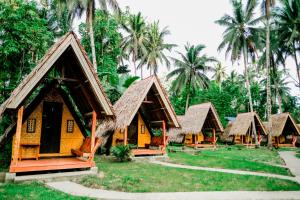 CamisanLoboc Nipa Huts Cottages Rental的一组棕榈树小屋