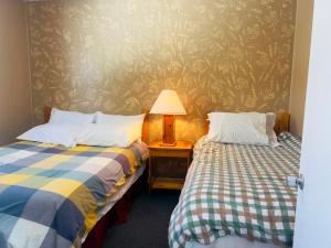 苏圣玛丽格伦维尤别墅酒店的一间卧室设有两张床和一张桌子上的台灯。