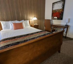 拉拜21号宾馆的一张床位,位于酒店客房内,配有书桌和一张四柱床