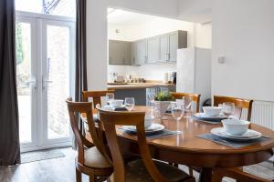 奇德尔Cheadle village的厨房以及带木桌和椅子的用餐室。