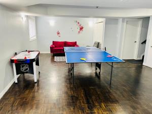 皮克灵Furnished Family Home near Toronto - Great Location Game Room - Backyard - Parking & Self Checkin的一间设有乒乓球桌和红色沙发的房间