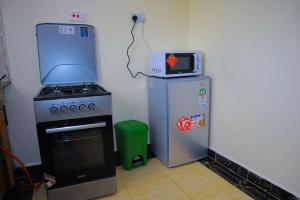 Langata RongaiSpringStone executive suite Rm 2的厨房配有炉灶、微波炉和冰箱。