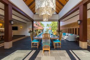 利巴诺伊Baan Tao Talay - Beachfront Private Villa的一间带桌椅和吊灯的用餐室