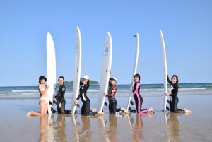 万宁万宁小刚驿栈的一群站在海滩上的妇女,她们有冲浪板