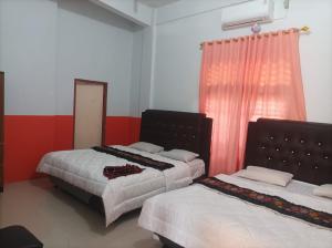 BangkinangHotel Al Madinah Bangkinang的一间卧室设有两张床、镜子和窗户