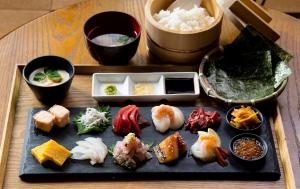 汤河原町和京日式酒店的一张桌子,上面放着一盘寿司和其他食物